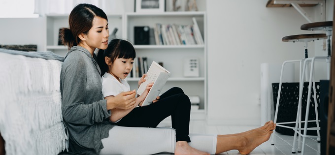 Seated Mother Reads to Daughter