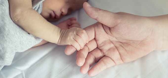 Baby holding mother's finger