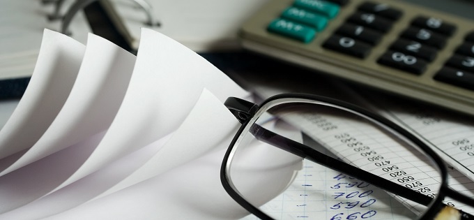 Glasses, calculator and paper