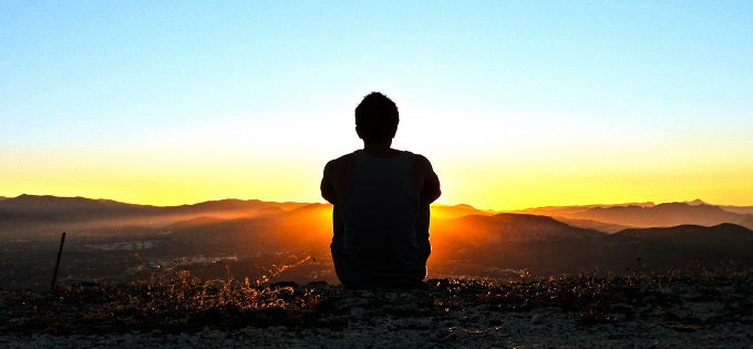 Person sitting at sunset