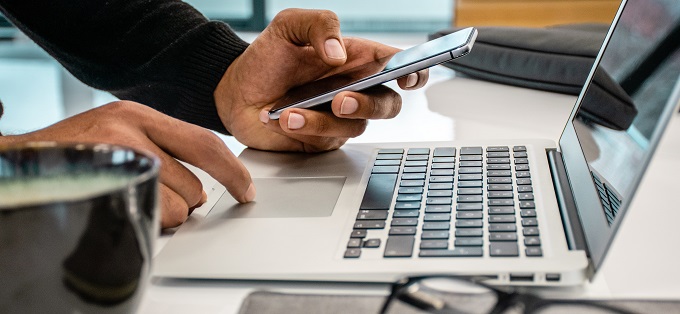 Man using phone and laptop