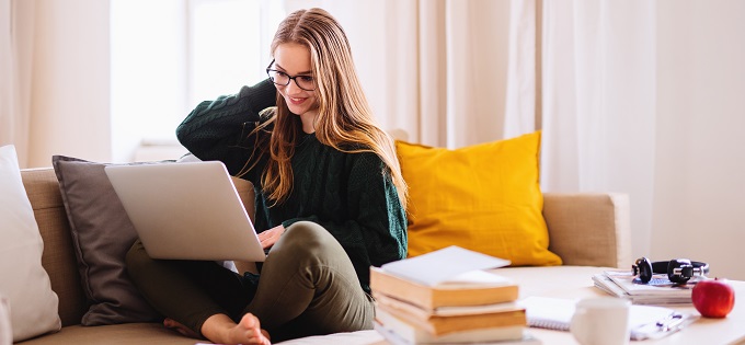 Young Woman on Sofa Studies Laptop