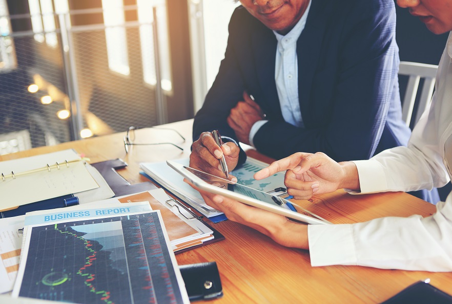 Investments-SidebySide-Men Looking at Tablets-882x594